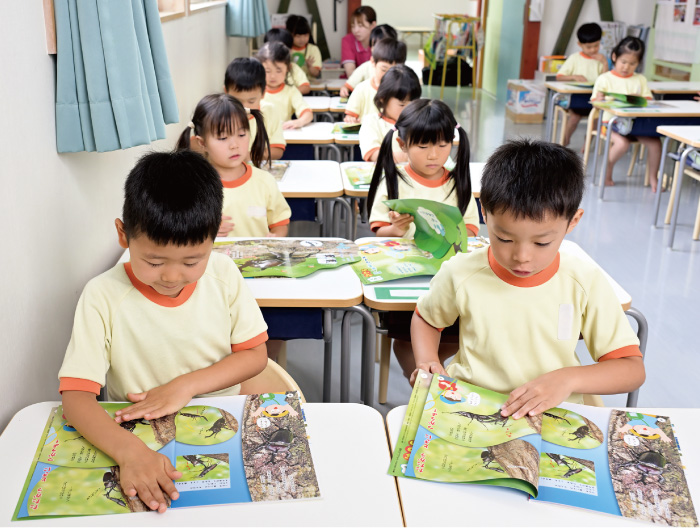 席について本を読むこどもたち